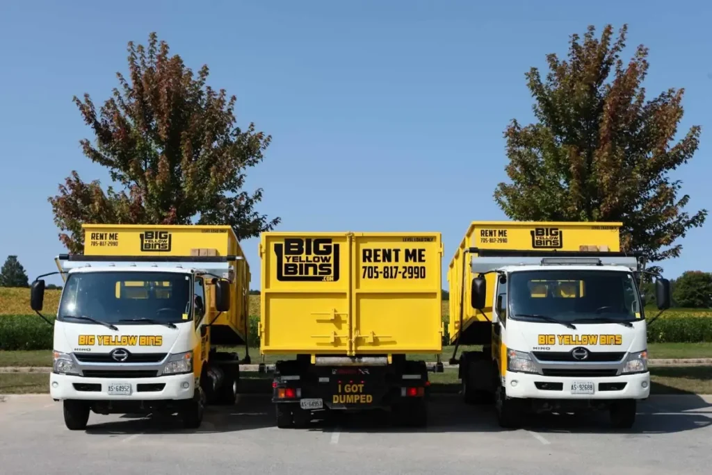 Three yellow dump trucks
